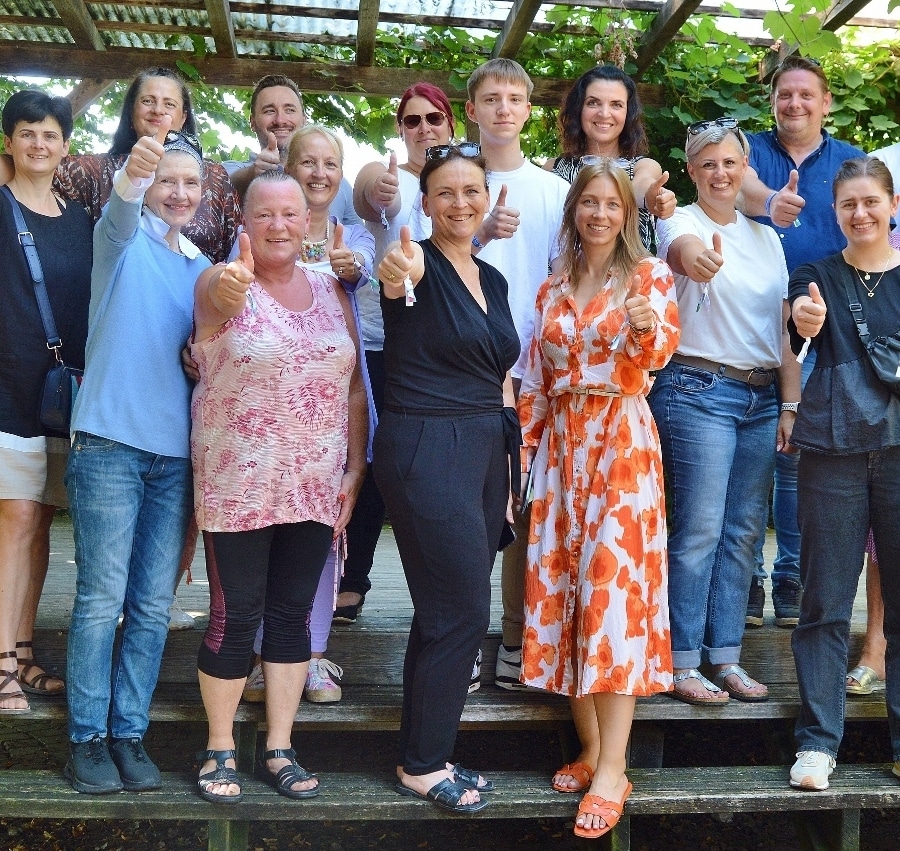 Gruppenfoto von Betreuer:innen und Begleiter:innen, bei denen alle den Daumen nach oben zeigen.